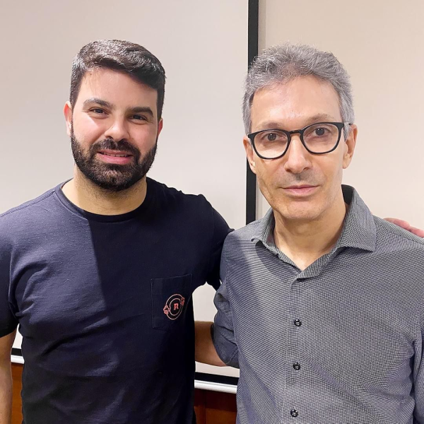 Romeu Zema e Sérgio Victor um ao lado do outro, em frente a uma parede branca; ambos olham para a câmera com um sorriso; foto ilustra matéria sobre possível candidatura a prefeito de Taubaté em 2024, pelo Partido Novo.