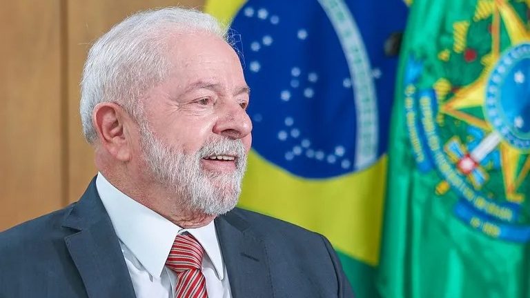 Presidente Lula de terno em frente a bandeira do Brasil; em pronunciamento de Natal ele citou que ódio a democracia desuniu famílias