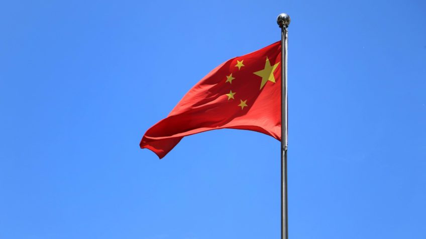 Bandeira da china com o céu azul no fundo.