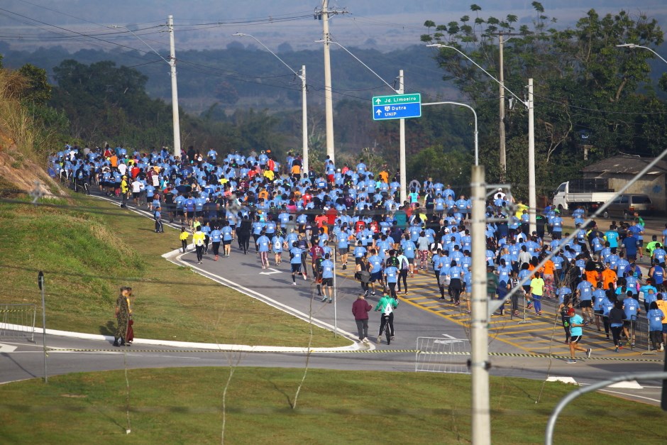 Corredores vestindo azul, na Via Oeste de São José dos Campos, durante corrida de aniversário da cidade.