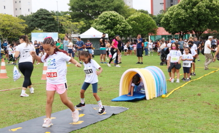 Crianças e pais brincando m gramado no Parque da Cidade de Jacareí.