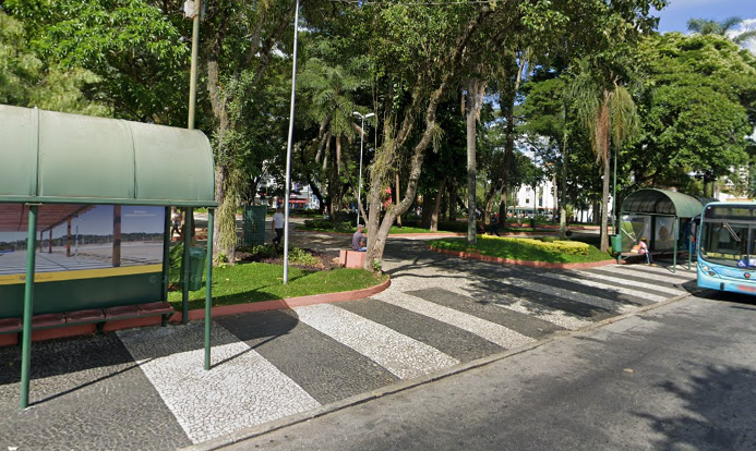 Trecho da praça Afonso Pena em dia de sol. É possível ver uma parte de um ponto de ônibus, à esquerda, árvores ao centro e um pedço de um ônibus municipal à direita.