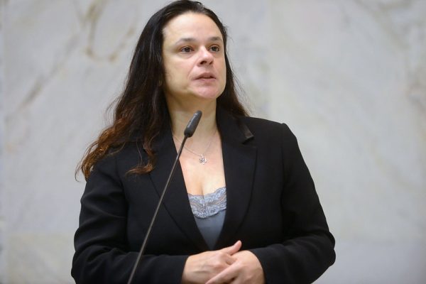 Janaína Paschoal, uma das candidatas ao senado por SP. Ela é branca e possui cabelo preto ondulado com mechas castanho claras nas pontas.
