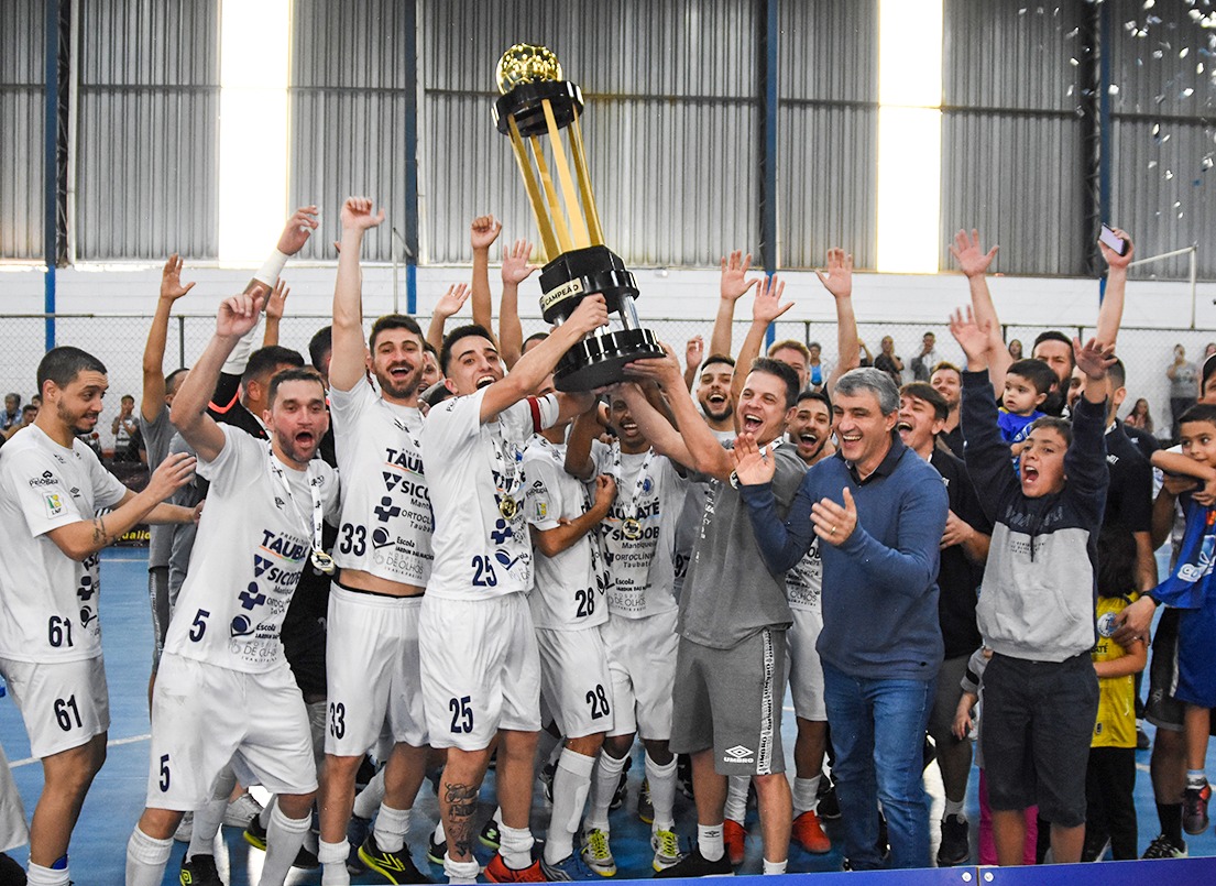 Ao lado do prefeito José Saud (MDB), jogadores do Taubaté Futsal levantam o troféu da Copa Oscar