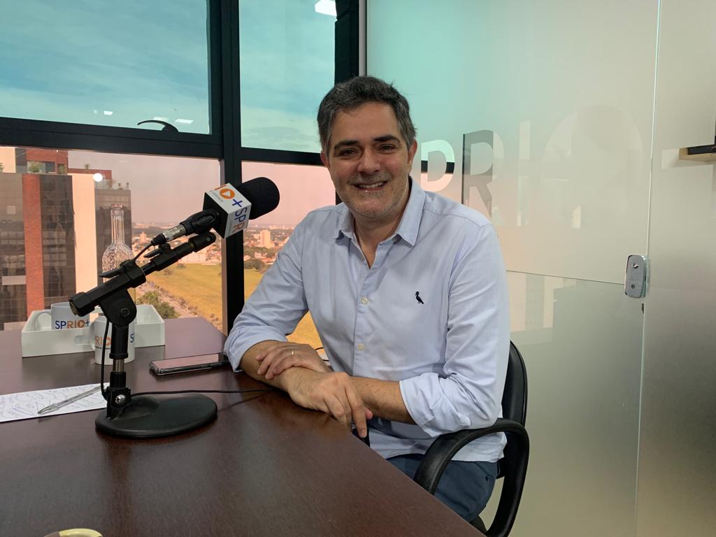 Ortiz Júnior sentado em mesa de entrevistas nos estúdios da SP RIO+. Ele foi prefeito de Taubaté em duas oportunidades.