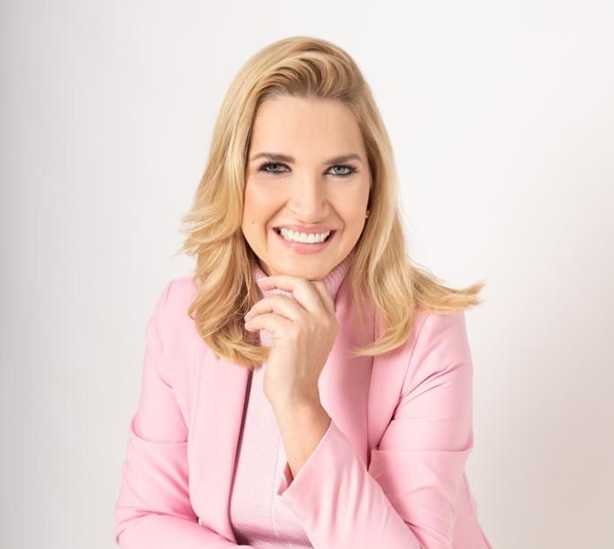 Retrato de Zilma Valadão com uma roupa rosa e com a mão escostada no queixo.