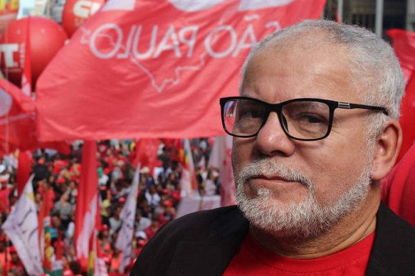 Antonio Carlos, um dos candidatos ao senado por SP. Ele é branco, calvo, possui cabelo barba com cavanhaque grisalhos. e usa óculos de grau preto.