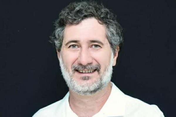 Titto Bellini, um dos candidatos ao Senado por SP. Ele é branco, possui olhos verdes, barba com cavanhaque grisalha e cabelo ondulado preto com tons de grisalho.