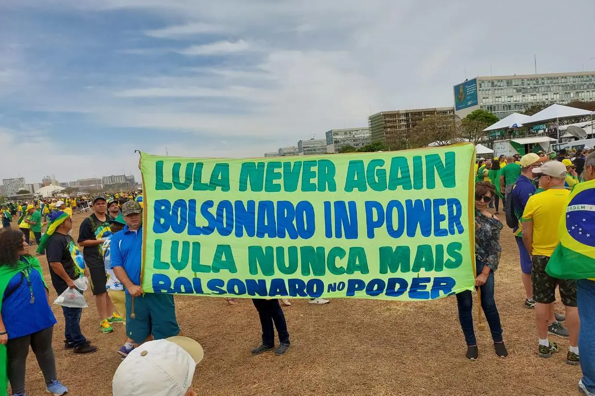 Manifestantes levantam cartaz verde, com letras em azul, apoiando o presidente Bolsonaro neste 7 de setembro.