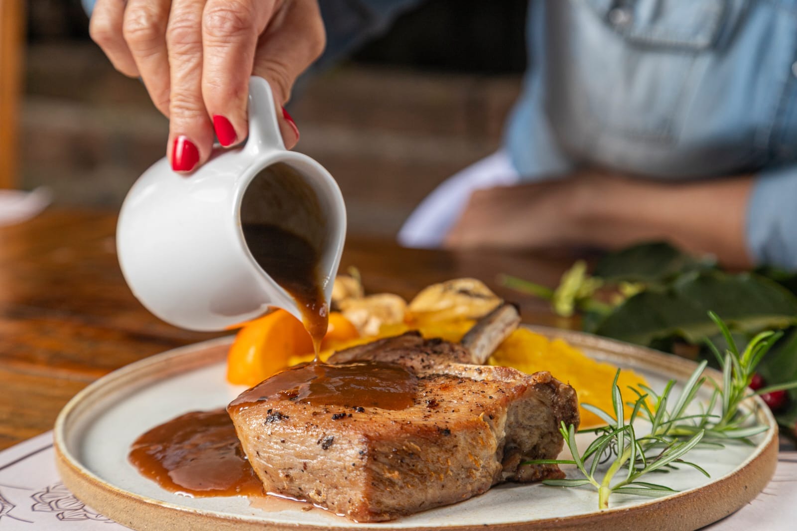 Prato com o prime rib suíno ao molho de café, que acompanha purê de mandioquinha e farofa de bacon.