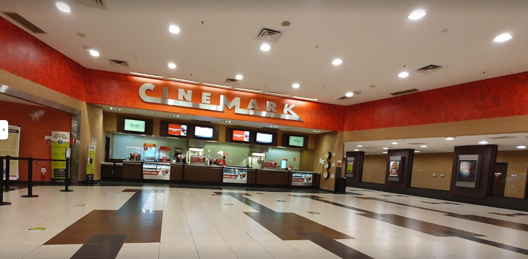 Fachada do Cinemark do Shopping Colinas, com um piso branco e marrom, os caixas ao fundo e um corredor à direita.