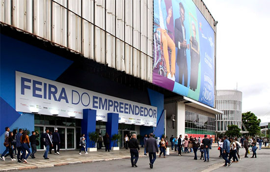 Fachada da Feira do Empreendedor 2022, onde São Sebastião irá visitar, com uma fachada azul e pessoas andando em volta.