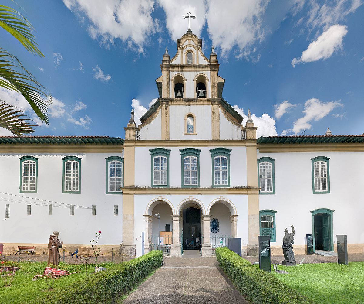 Museu de Arte Sacra de São Paulo, uma das instituições culturais do estado, com um gramado na frente, estátuas nas laterais, janelas no prédio e um céu azul.