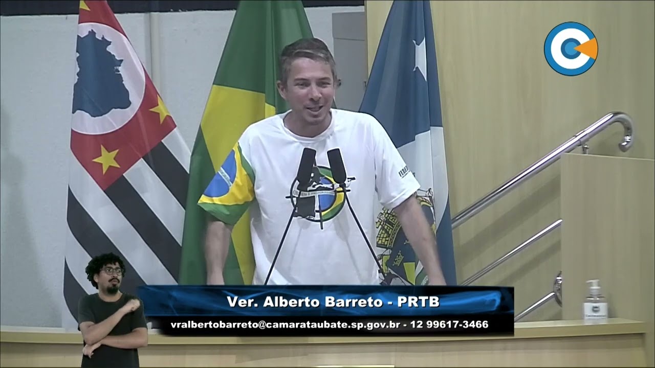Alberto Barreto com camiseta branca e bandeiras do Brasil, SP e Taubaté.