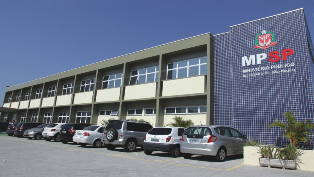 Fachada do Ministério Público de SP, que investiga casos de assédio eleitoral no Vale do Paraíba, ilustrando a matéria, com céu azul, carros estacionados e janelas do estabelecimento.