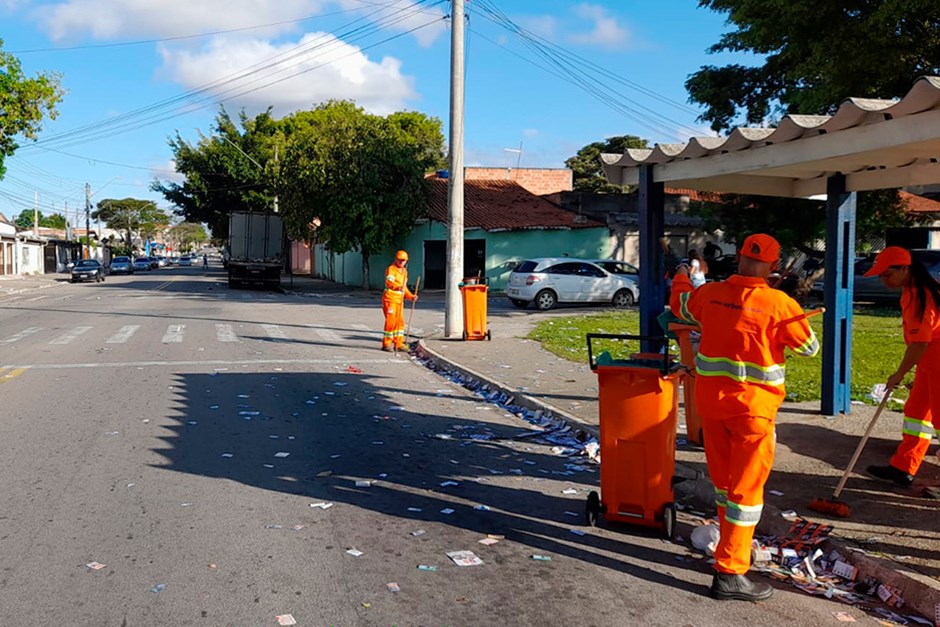 Imagem mostra garis em São José dos Campos recolhendo santinhos das ruas após as eleições