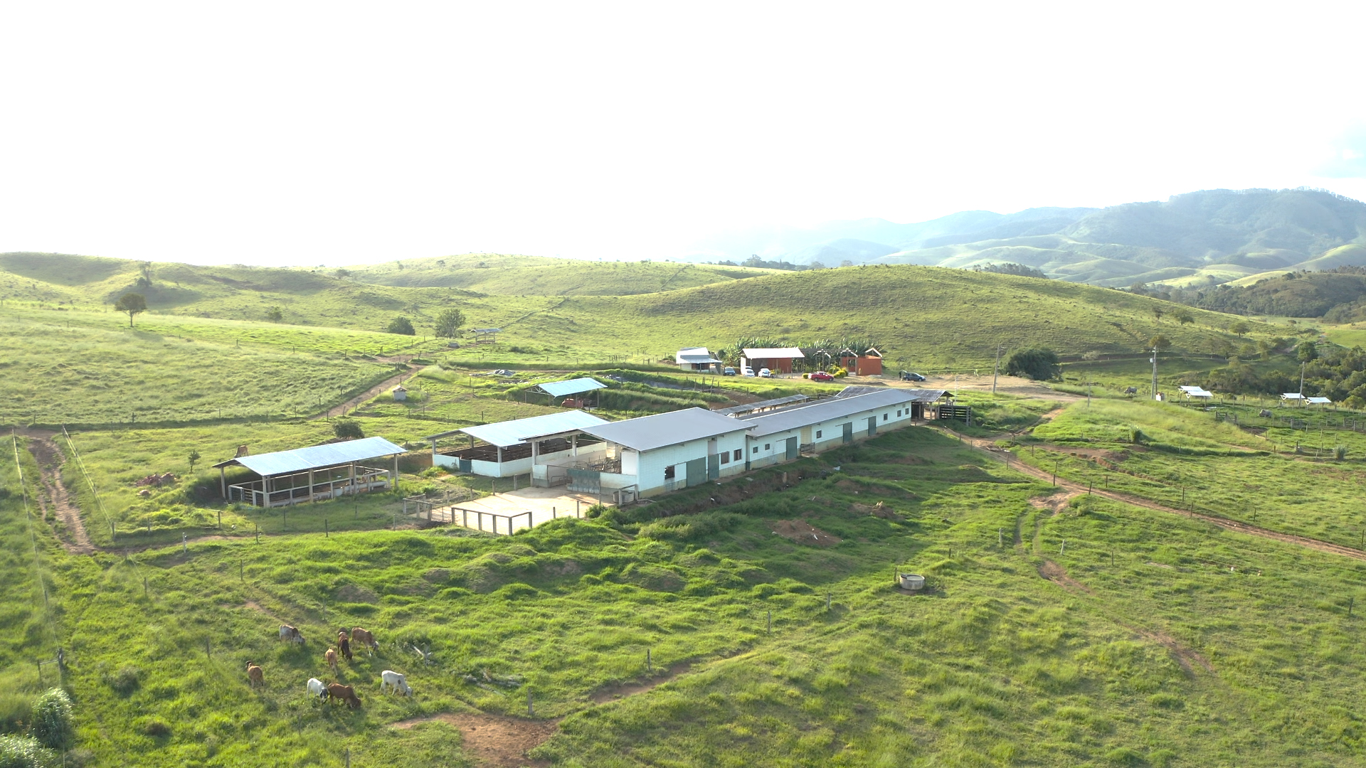 Vista aérea da Estância Silvânia, com área verde ao lado, a construção no meio e o céu azul em cima.