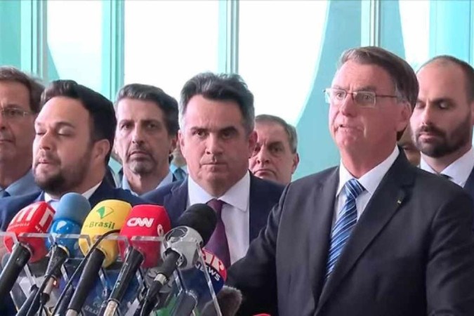 Foto mostra Bolsonaro durante seu primeiro discurso após perder as eleições, em frente à aliados, com microfones da imprensa.
