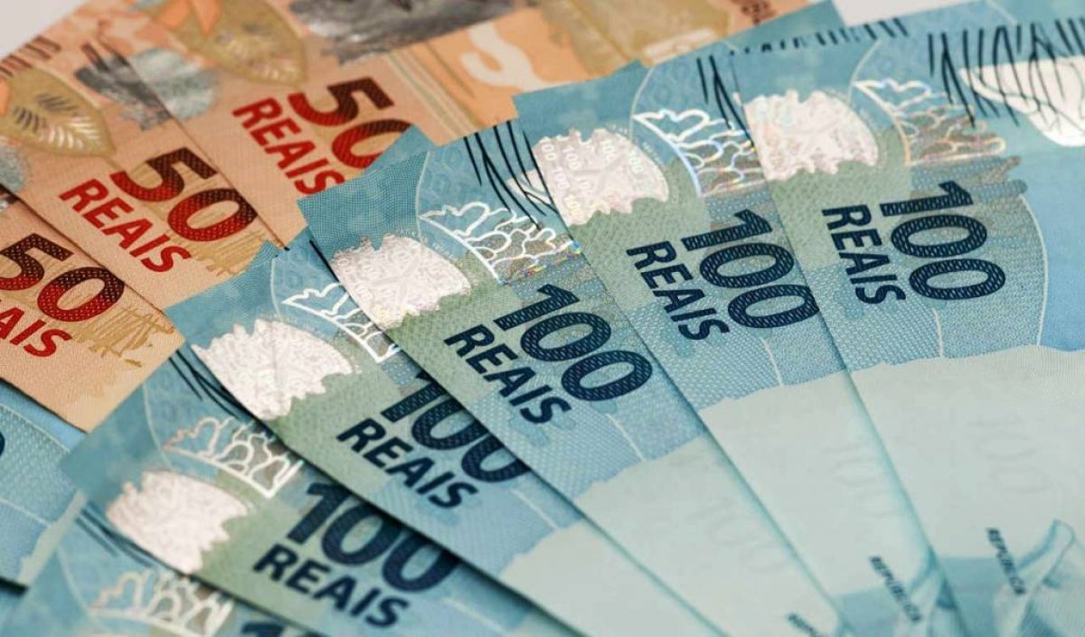 Notas de dinheiro, enfileiradas, nas cores azul e marrom, ilustrando o anúncio do projeto Taubaté Decide.