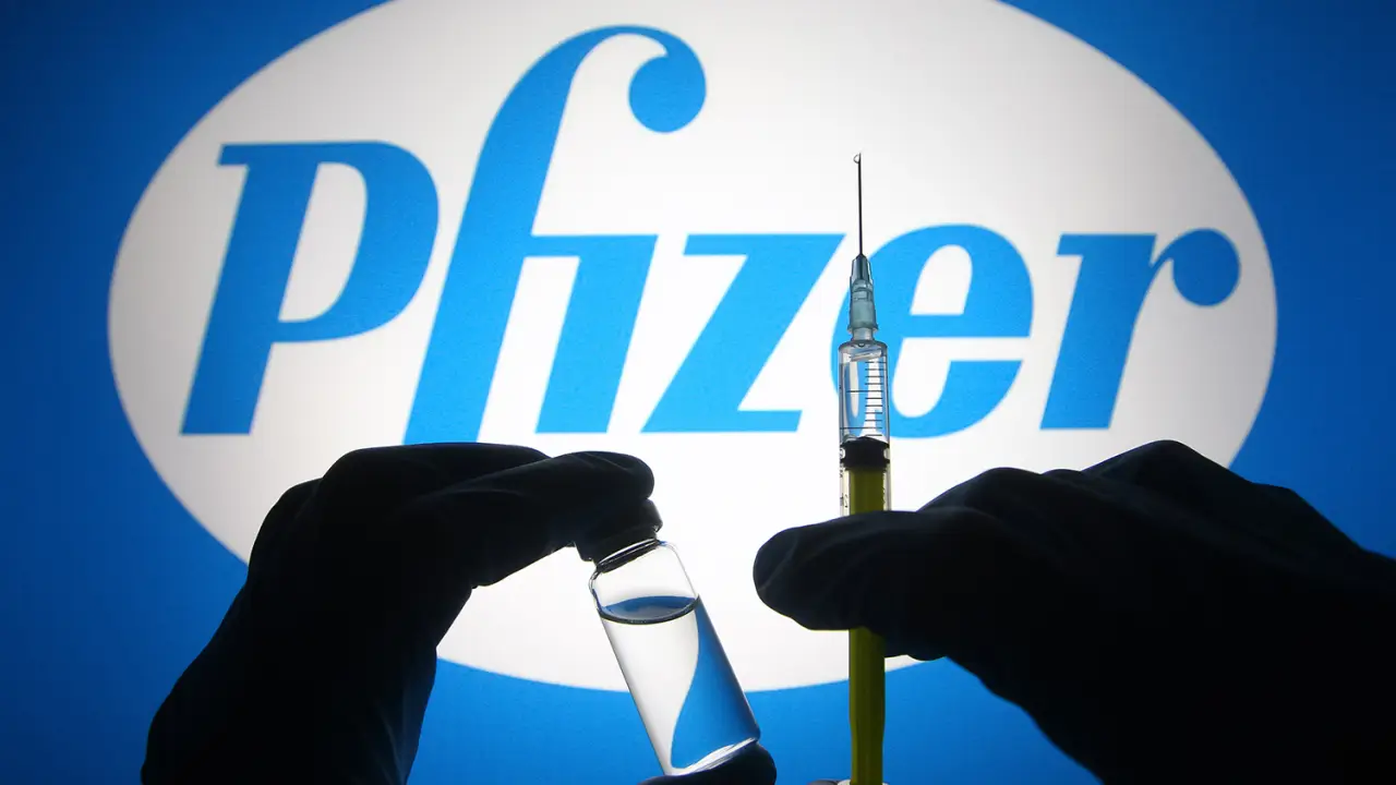Mão segurando vacina da Pfizer contra a covid.