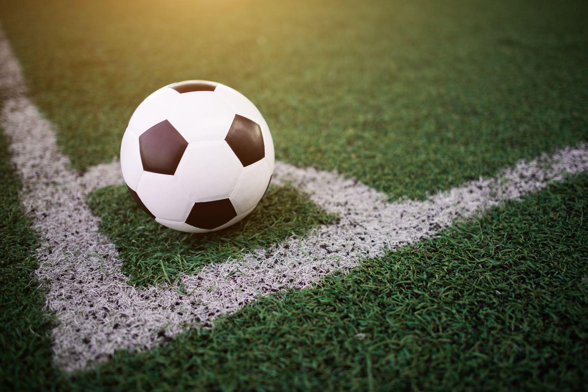 Bola de futebol branca e preta no canto do gramado verde, com as linhas brancas, ilustrando a matéria que a Holanda vence o Catar.