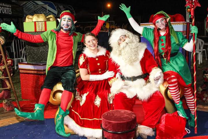 Atores da peça teatral “Os ajudantes do Papai Noel”, todos com roupas vermelhas e verde; foto ilustra a matéria do Teatro Colinas, em SJC.