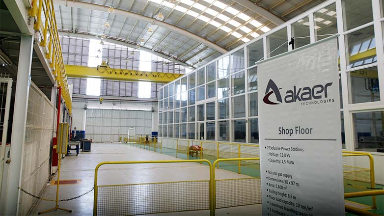 Parte interna da Akaer, em SJC, com grades amarelas, vidros e luzes no teto.