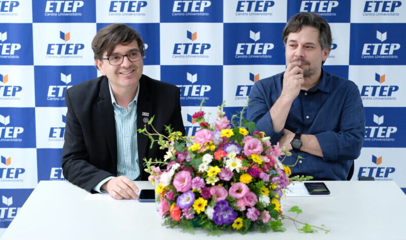 fabiano roxo e thiago pegas, da etep faculdades, em um fundo azul e branco com um buquê de flores na mesa.