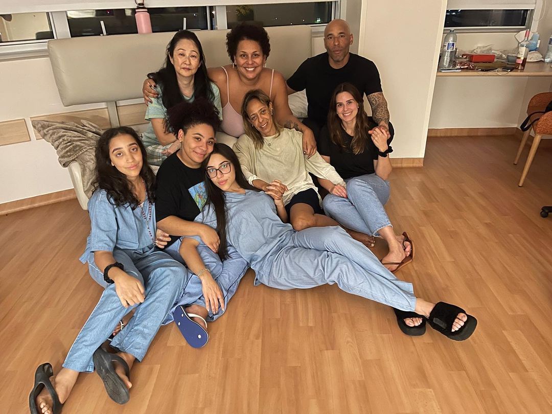 Família de Pelé no Hospital Albert Einsten, em um chão de madeira, sentados em um banco.