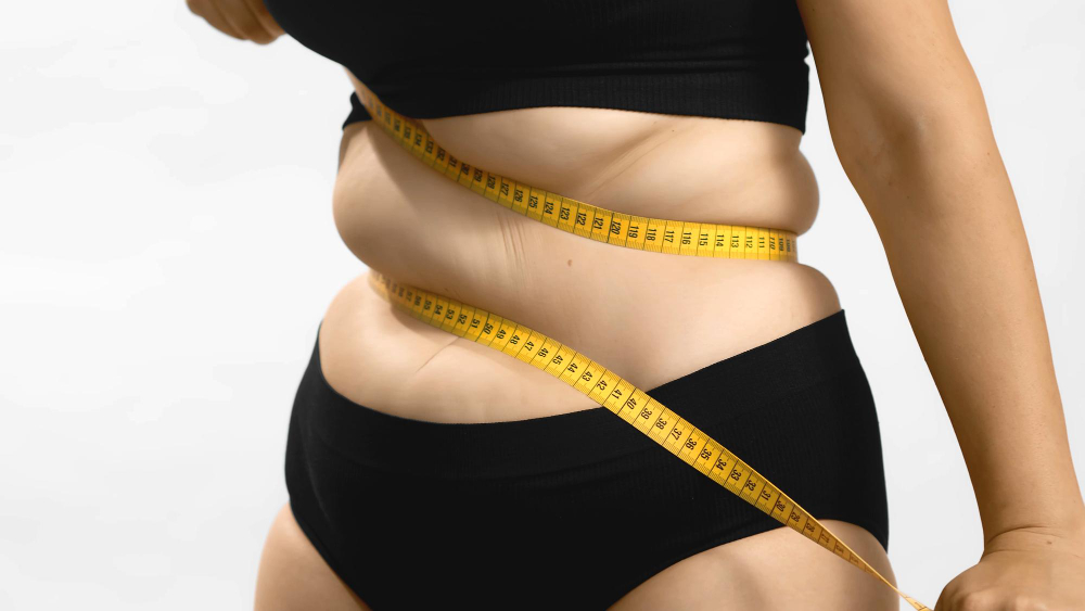 Pessoa obesa, com roupa preta, com uma fita métrica pelo corpo; foto ilustra a matéria sobre o Projeto Vida Leve, de São Sebastião.