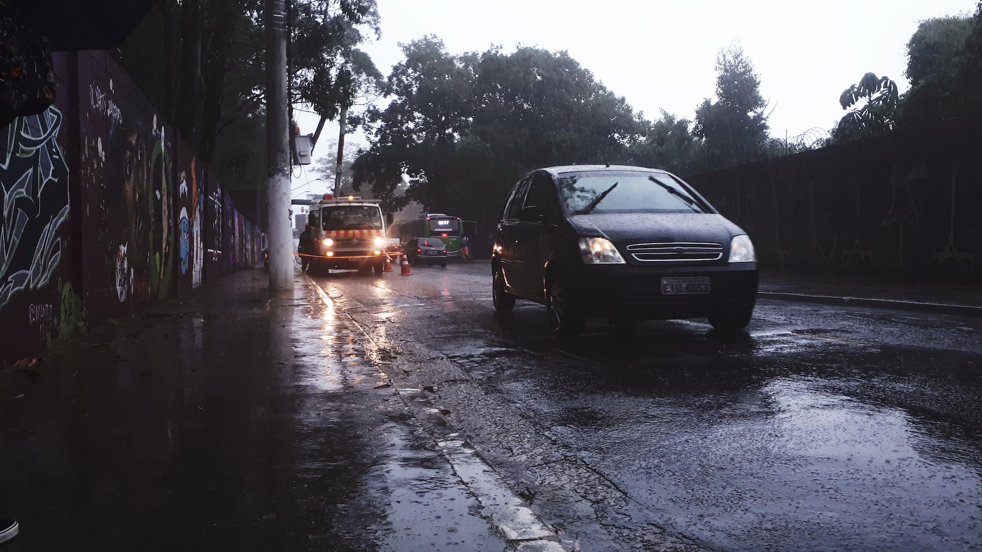 trânsito com carros passando em rua brasileira em dia de chuva
