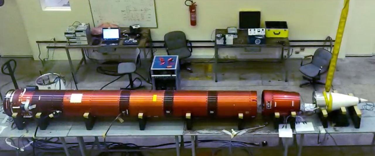 Plataforma lançada pela Orbital Engenharia em outubro deste ano, nas cores laranja e preta, apoiada em uma mesa, com computadores ao fundo.