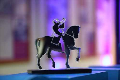 Trófeu do prêmio 'Cidade Destaque Mobilidade', vencido por São José dos Campos. O troféu parece feito de metal e mostra homem em cima de cavalo tocando uma espécie de corneta.