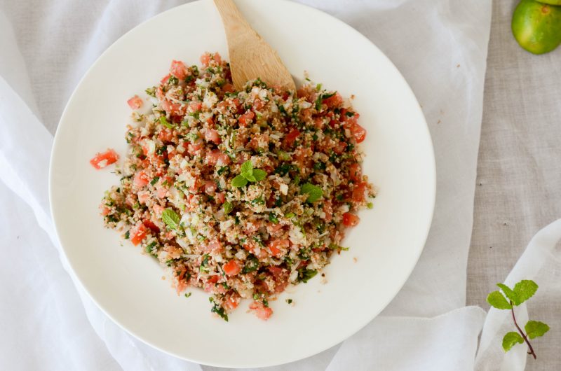 Tabule árabe em um prato branco, com uma colher de madeira, em cima de uma mesa com toalha branca, ilustrando a matéria sobre a ceia plant-based.