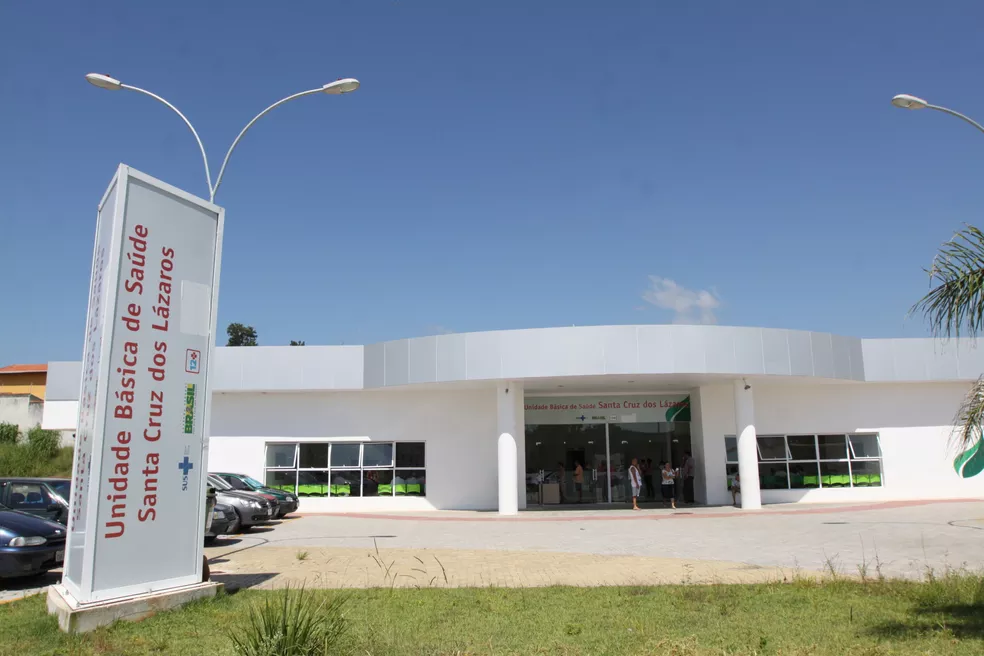 Fachada da UBS Santa Cruz dos Lázaros, em Jacareí, com céu azul, gramado na frente e carros estacionados; foto ilustra a matéria sobre o processo de médico generalista em Jacareí.