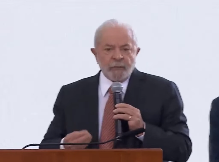 Lula durante encontro com lideranças sindicais, com terno preto, camisa branca, gravata vermelha; foto ilustra sobre imposto para os pobres.
