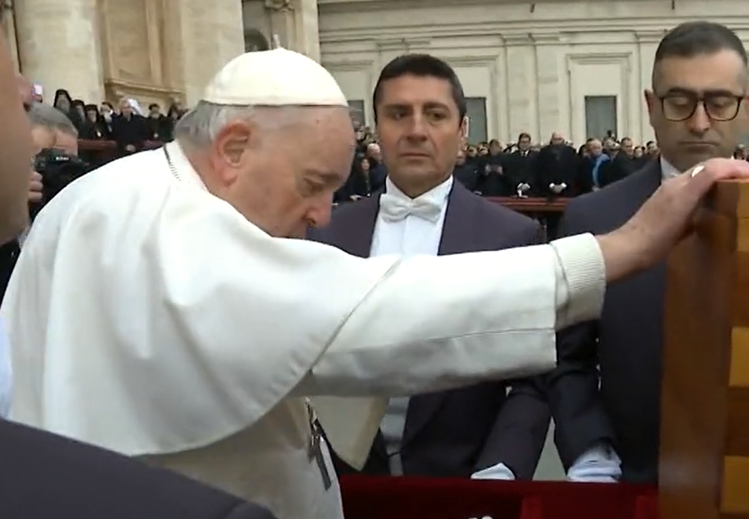 Foto mostra Papa Francisco se despedindo de Papa Bento XVI durante seu funeral no Vaticano; com roupas brancas e pessoas em volta.