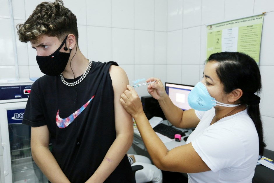 profissional da saúde aplicando vacina no braço de jovem em são josé dos campos.