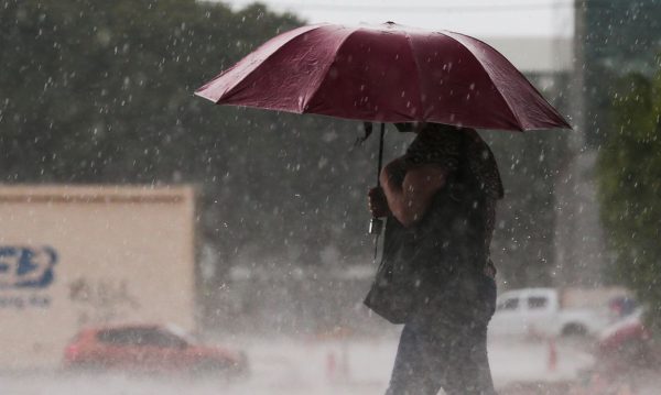 imagem de uma pessoa com guarda-chuva aberto, por conta de um temporal; foto ilustra matéria sobre alerta da Defesa Civil para chuvas intensas na região do Vale do Paraíba