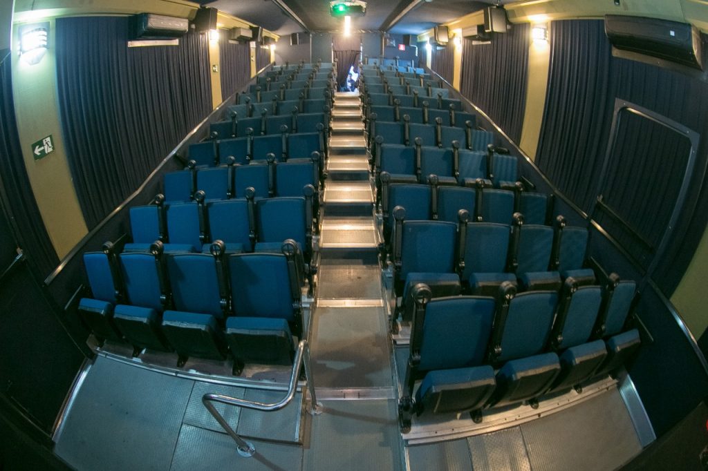 imagem de uma sala de cinema, dentro de um caminhão; foto ilustra matéria de cinema gratuito e itinerante, que chega em Taubaté e Lorena