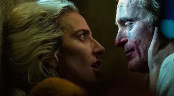 imagem da atriz Lady Gaga ao lado do ator Joaquin Phoenix; foto listra matéria sobre Lady Gaga interpretando a personagem Arlequina no filme