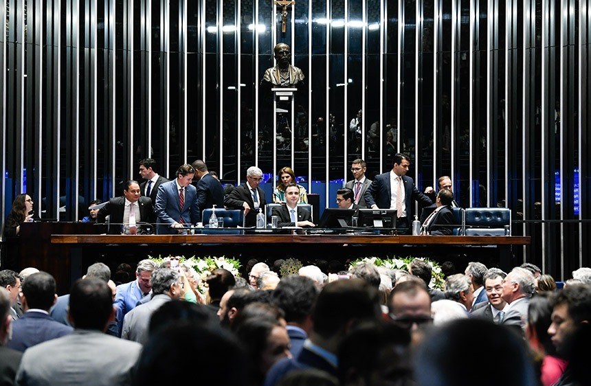 Mesa Diretora do Senado é definida; foto mostra pessoas ao fundo, computadores e cores escuras.