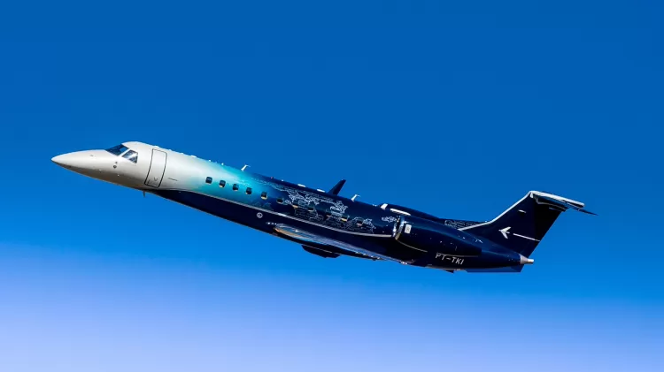 Embraer Legacy 650E, sobrevoando um céu azul, para a esquerda; foto ilustra matéria sobre entrega de jatos em 2022.