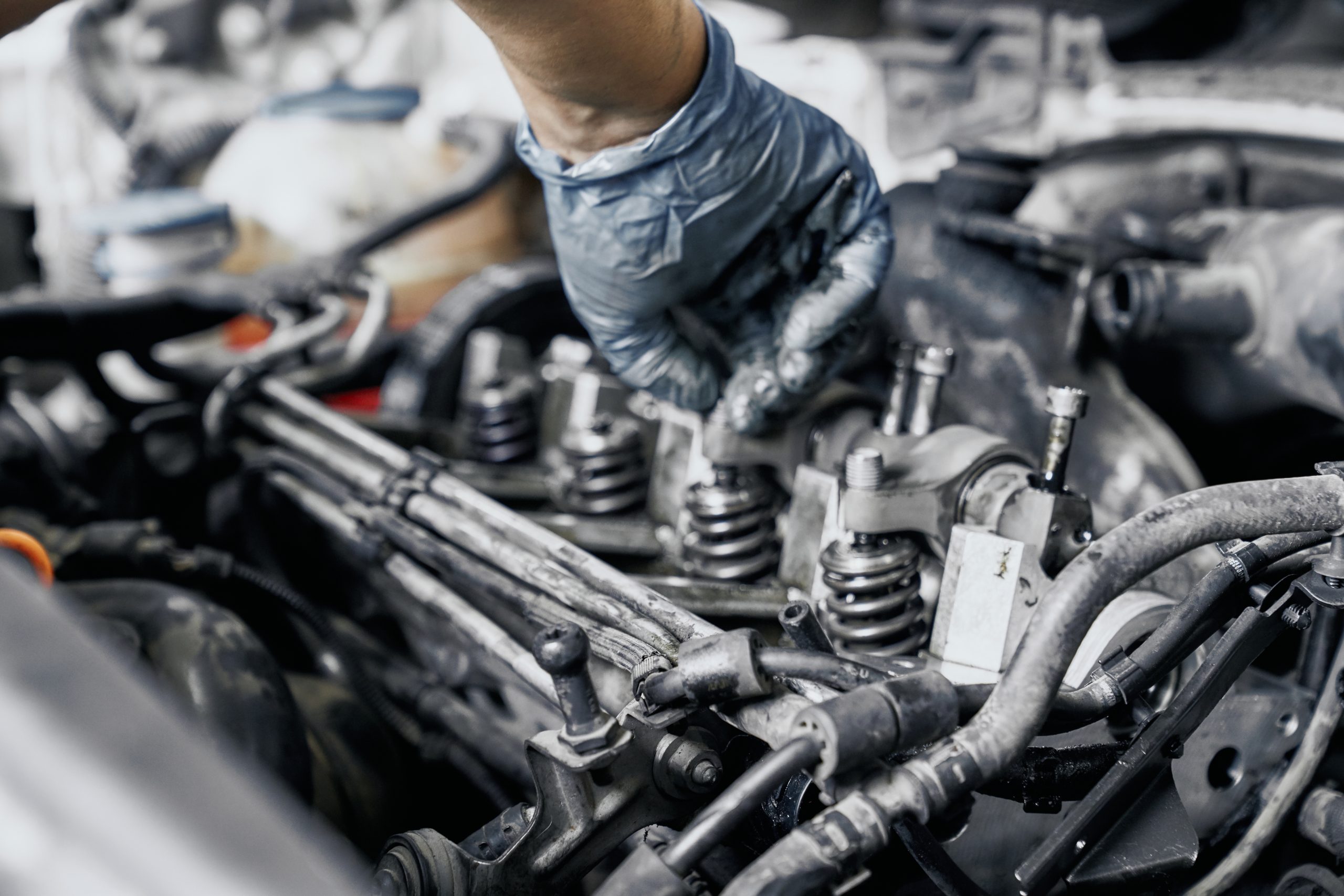 mão de um mecânico fazendo alguns reparos no motor do carro; foto ilustra matéria sobre cuidados necessários com o carro, antes de viajar
