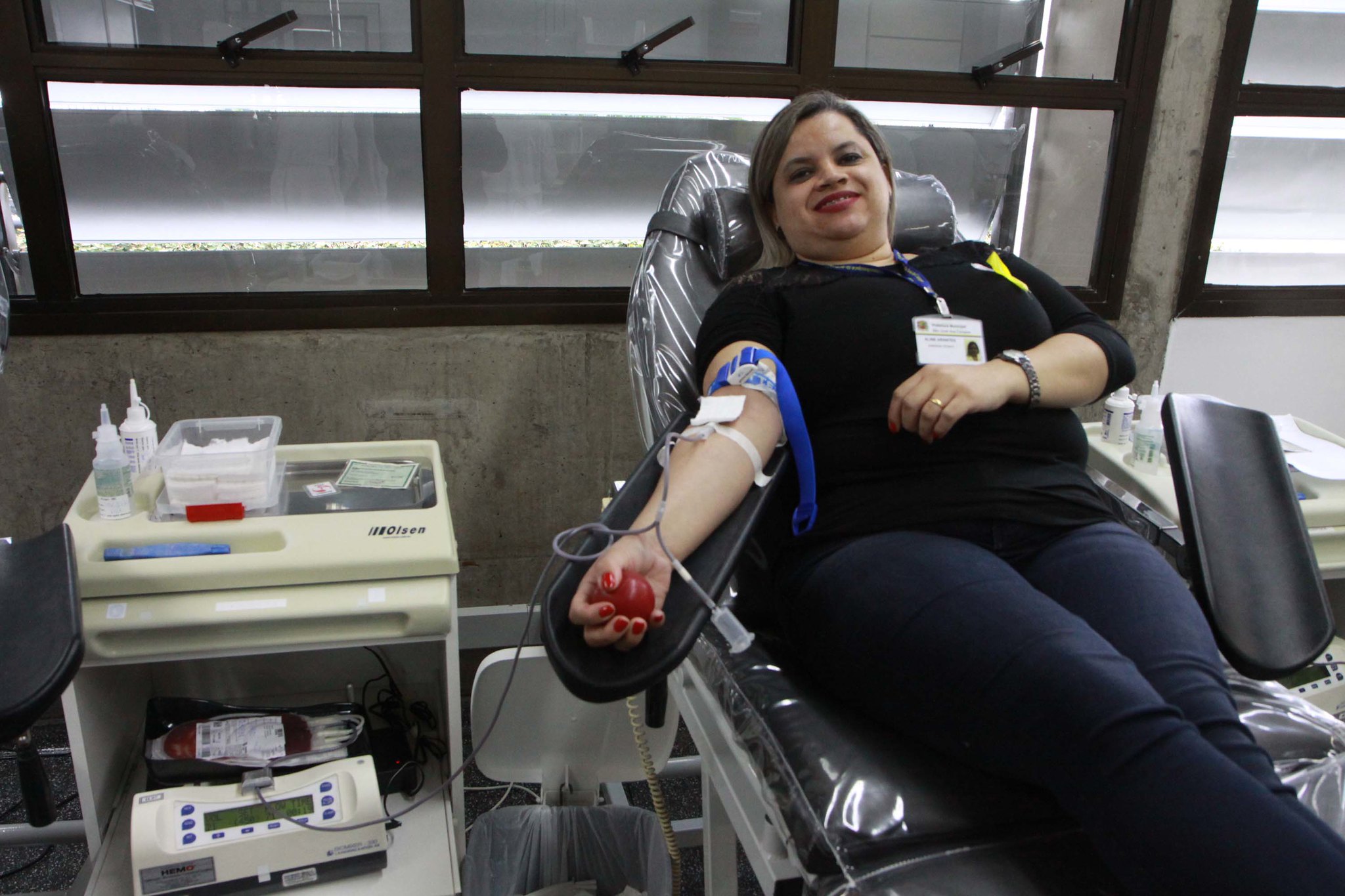 mulher sentada em maca doando sangue em São José dos Campos
