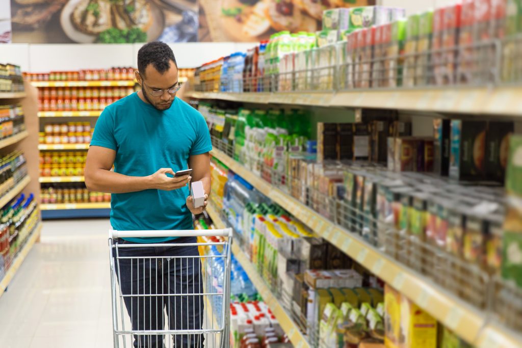 imagem de um homem fazendo compras no supermercado; foto ilustra matéria sobre Embalagens ocultam informações de alimentos vendidos no Brasil