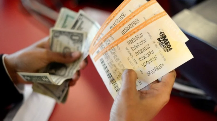 imagem de uma mão segurando bilhetes da Mega Millions; foto ilustra matéria sobre Loteria americana Mega Millions sorteio prêmio de R$ 1,5 bi e brasileiros podem participar