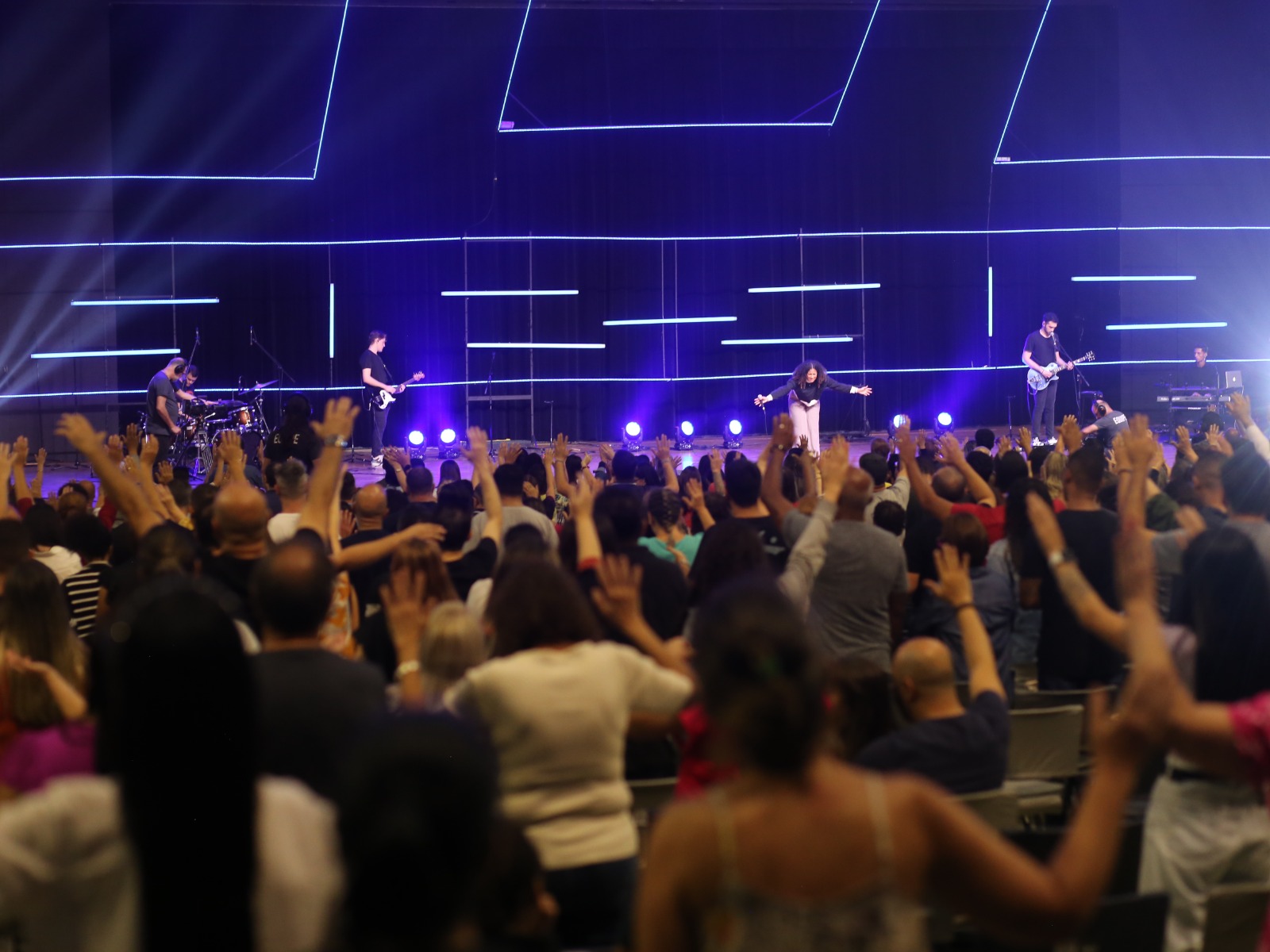 Foto ilustra o programa 30 Semanas, realizado pela Igreja da Cidade de São José dos Campos, com fundo azul e pessoas com os braços levantados.