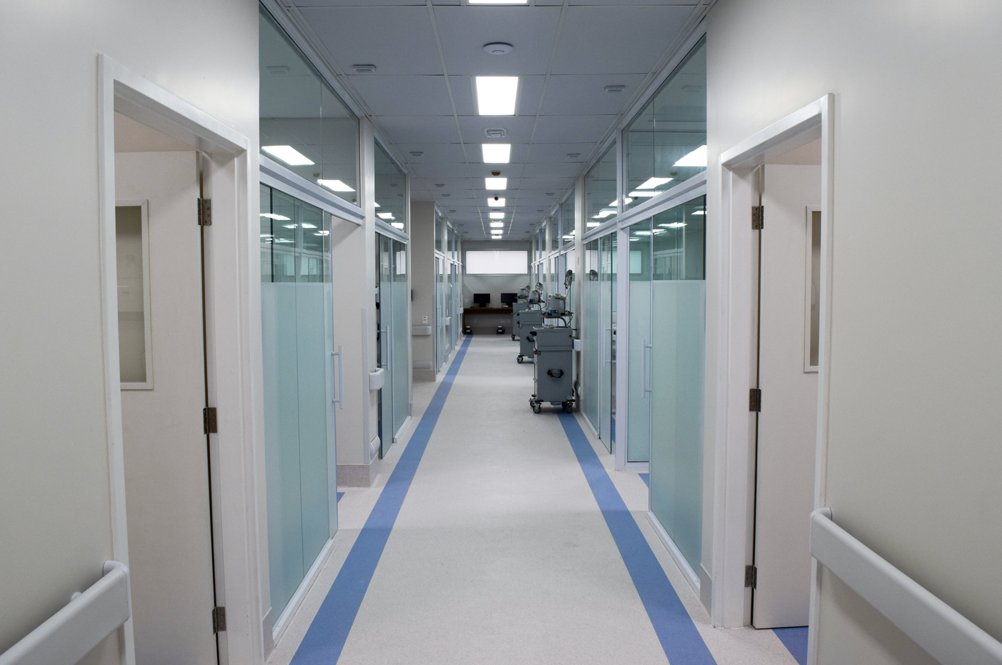 Nova área na Santa Casa de São José dos Campos (SJC), que será inaugurada na próxima semana; foto mostra corredores brancos, piso com detalhe em azul, portas nas laterais e vidros ao fundo.