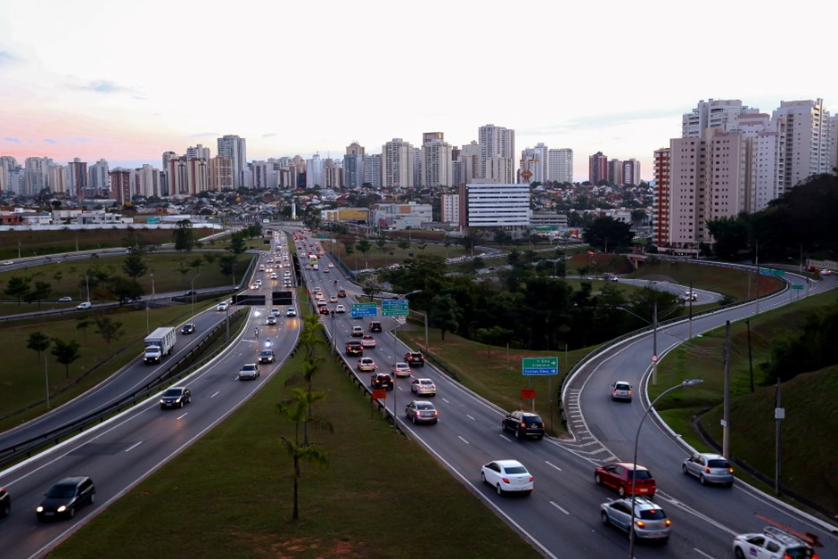 Anel Viário de São José dos Campos; foto ilustra matéria sobre obras e interdição e mostra carros andando sentido norte, com prédios ao fundo e área verde no centro.